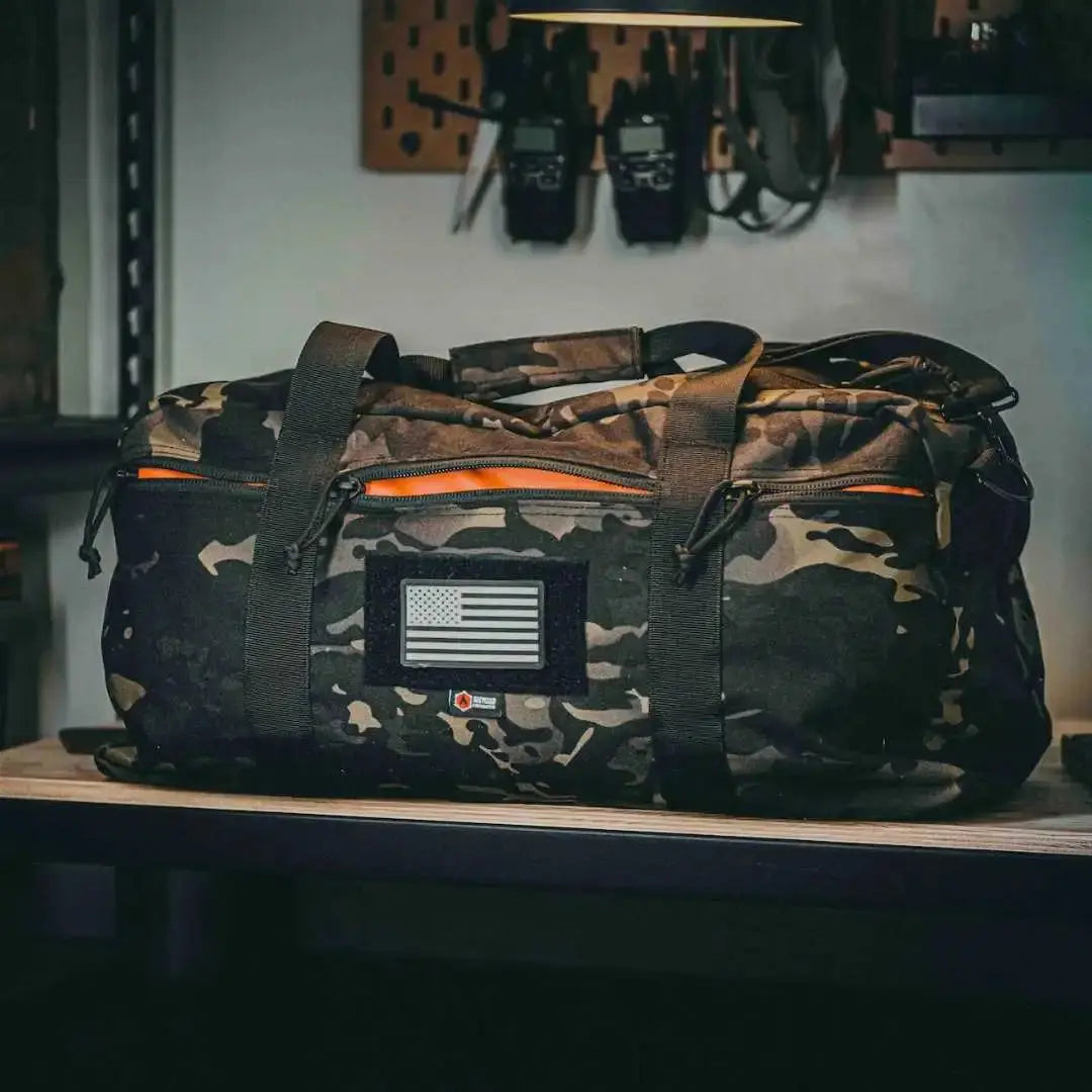 72-Hour Duffle Bag in camo pattern with American flag patch and orange interior.