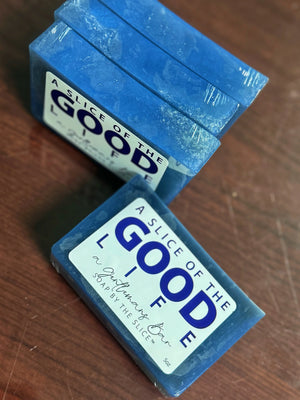Blue bar soap with white label reading "A SLICE OF THE GOOD LIFE" and "A Gentleman's Bar".