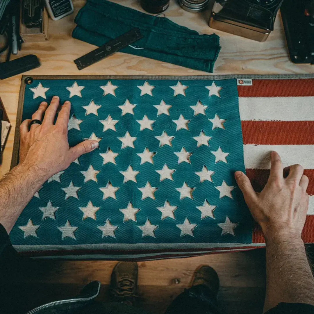 American flag made of red and white stripes and blue field with cut-out white stars.