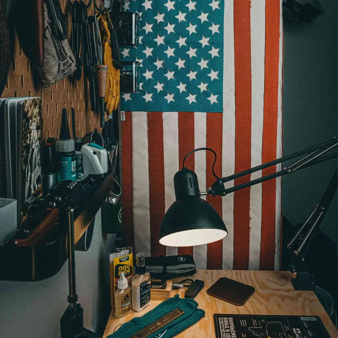 American flag made from fire hose, displayed on a workbench with tools.