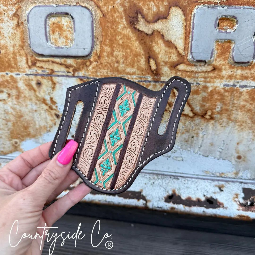 Hand-tooled Aztec leather knife sheath with turquoise and brown floral details.