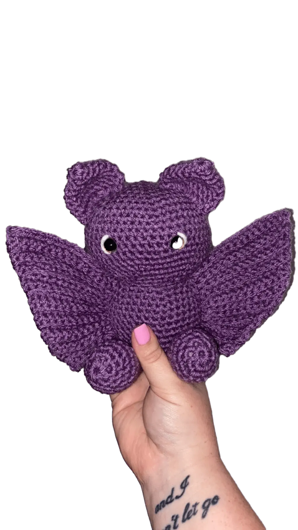 Crochet Purple Bat Plush Toy, Handmade Amigurumi by Main Street Collective. Cute handmade bat with wings, held in hand.