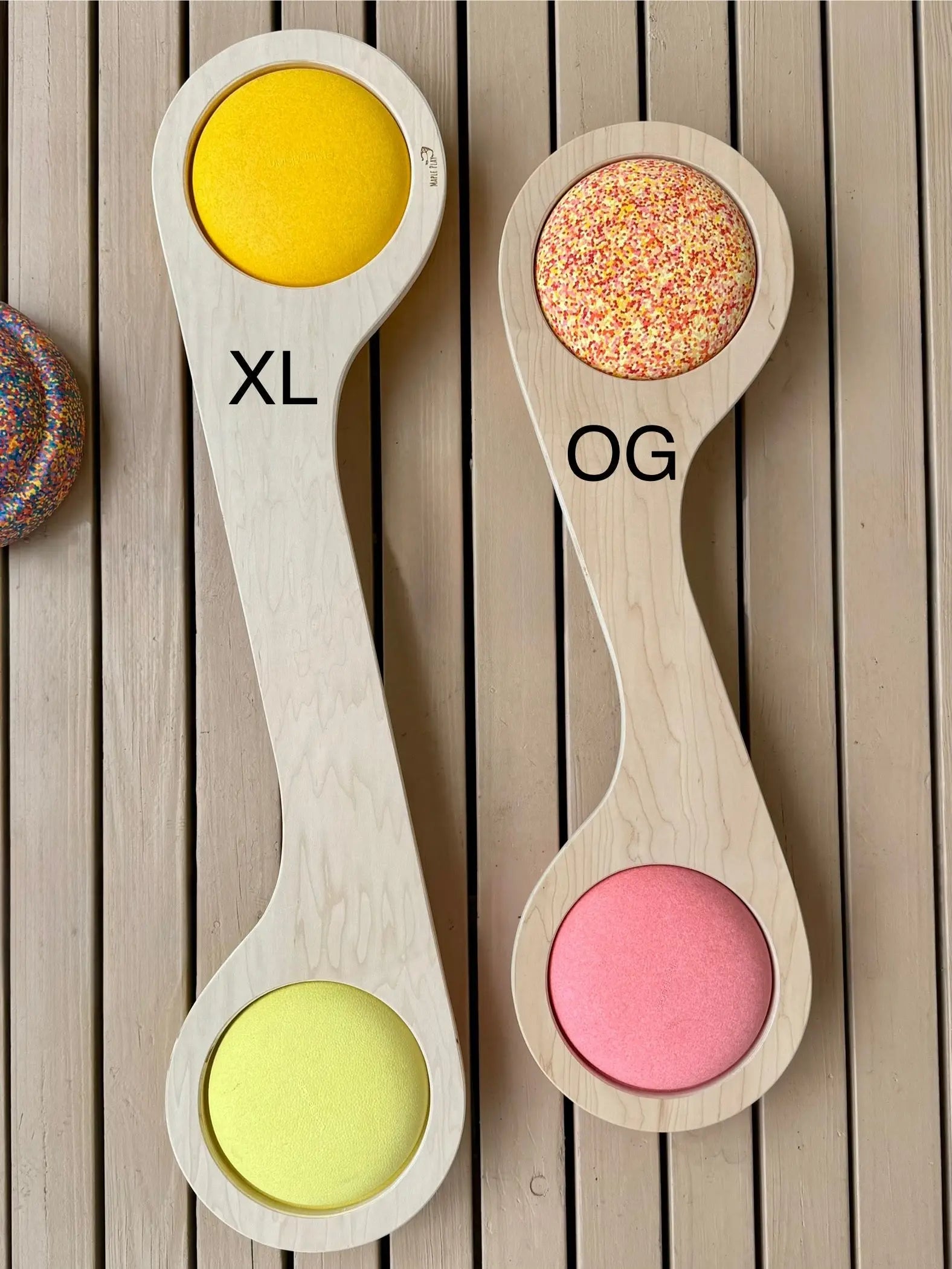 Wooden balance boards labeled XL and OG with colored play surfaces.