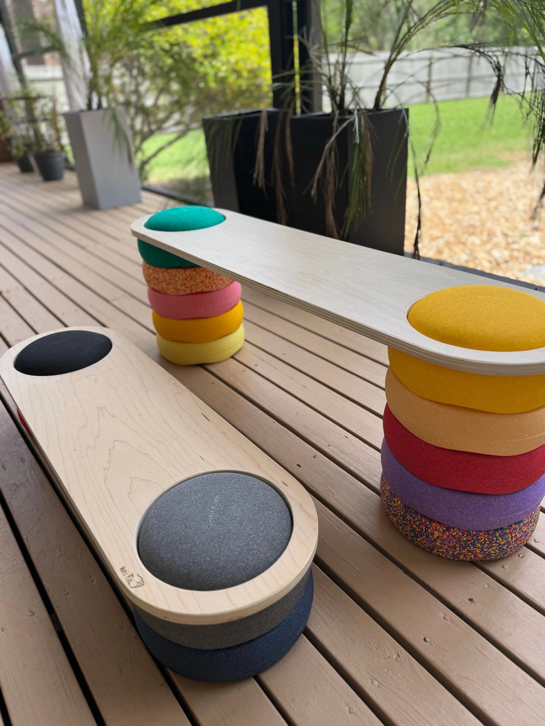 Wooden balance board with colorful cushions on a deck