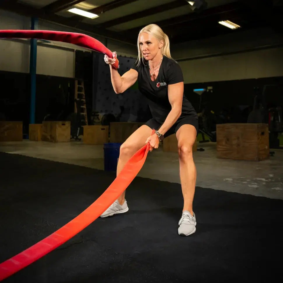 Woman using a red battle rope for exercise