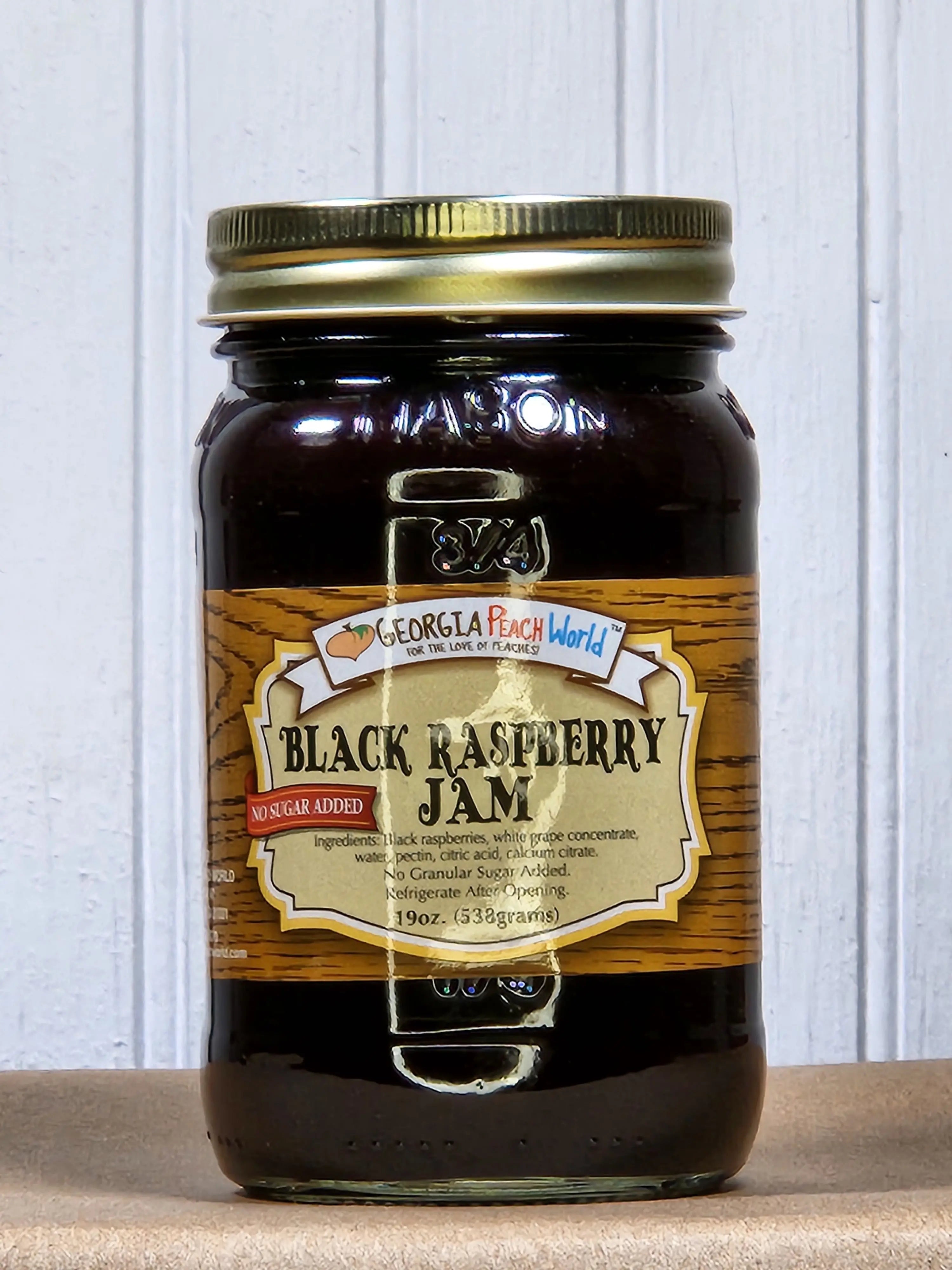 Glass jar of Georgia Peach World Black Raspberry Jam with 'No Sugar Added' label.