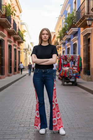 Woman in black shirt and upcycled boho patchwork jeans standing in a colorful city street.