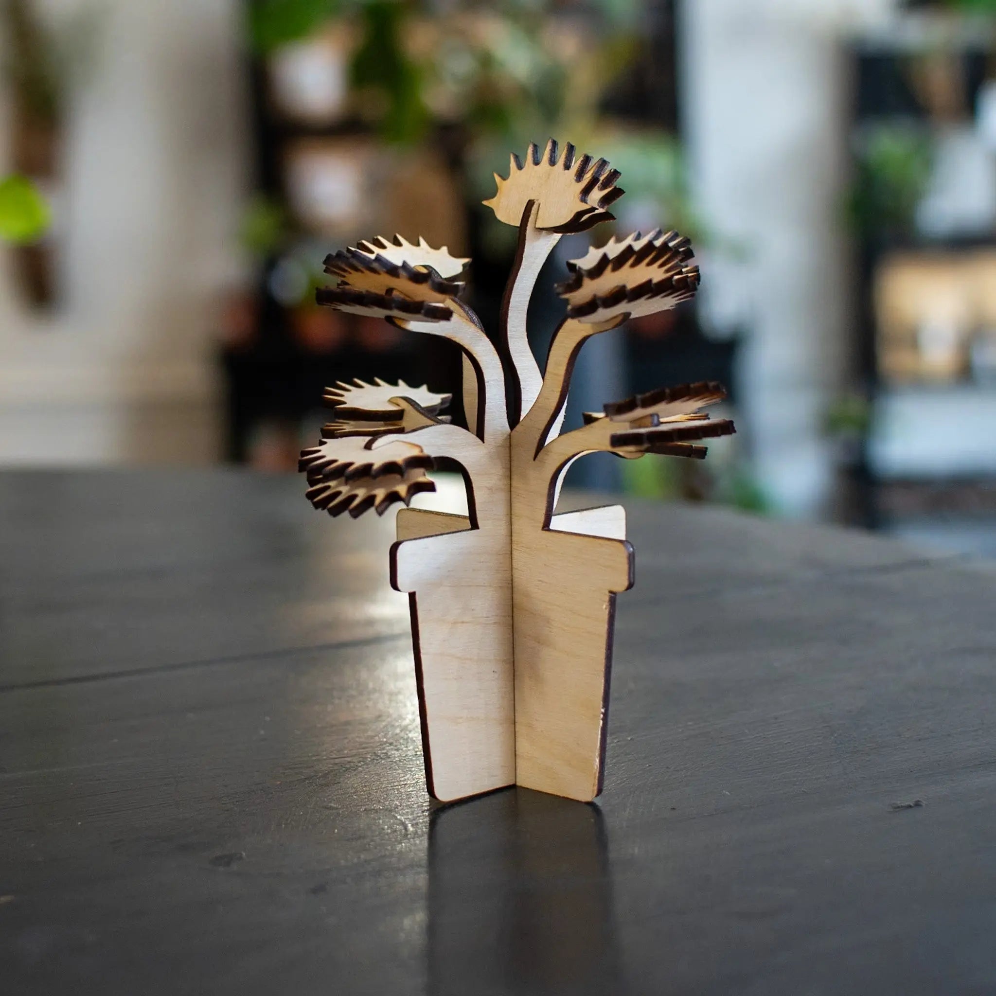 Laser-cut wooden Venus fly trap plant in a pot.