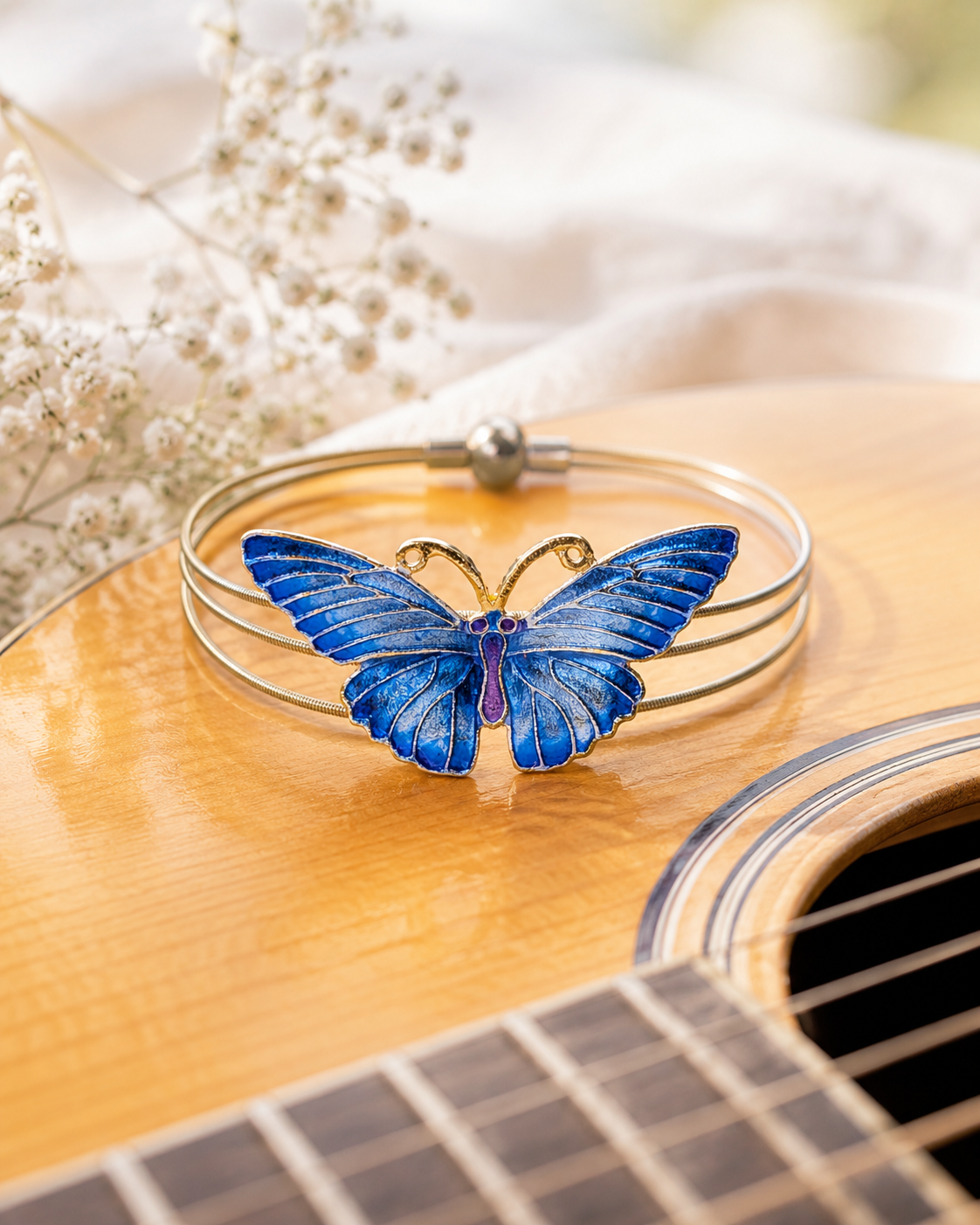 Blue butterfly bracelet on a guitar with flowers in the background