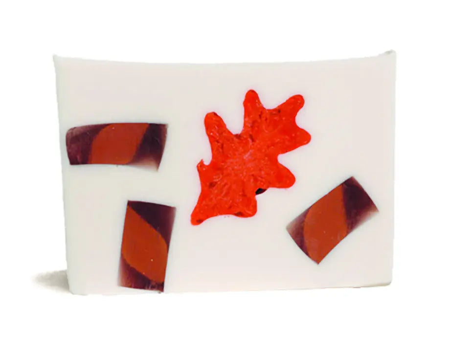 White soap slice with embedded orange leaf and stripe patterns.