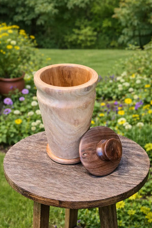 Wooden cremation urn made of mimosa and black walnut in a garden.