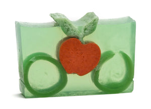 Green translucent soap bar with embedded orange apple shape and green leaf accents.