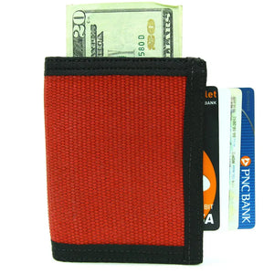 Red canvas bifold wallet with US dollar bill and credit cards.