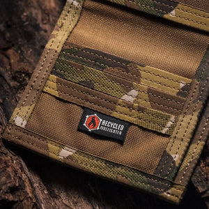 Close-up of a camouflage wallet with a "Recycled Firefighter" label made of combat leather.