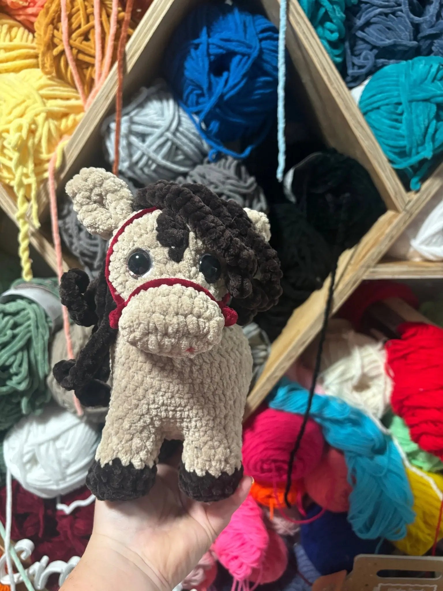 Handmade Crochet Horse Toy: Caspian from Main Street Collective. Colorful yarn background. Horse gift, crochet animal, amigurumi toy.