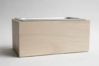 Magnolia wood countertop compost bin with stainless steel interior for kitchen food waste.