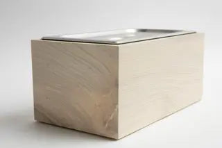 Magnolia wood compost bin with stainless steel insert and lid, rectangular shape for countertop use.