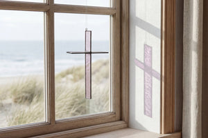 Burnt Amber Cross Suncatcher hanging in a window and catching natural light