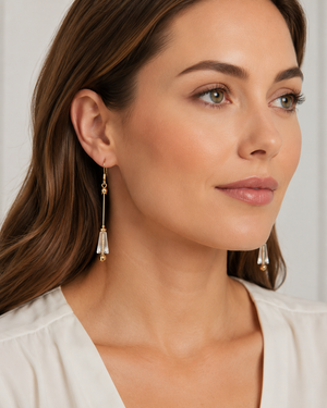 Woman wearing gold earrings with a plain background
