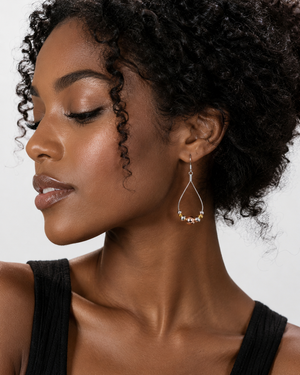 Woman wearing a hoop earring with a neutral background