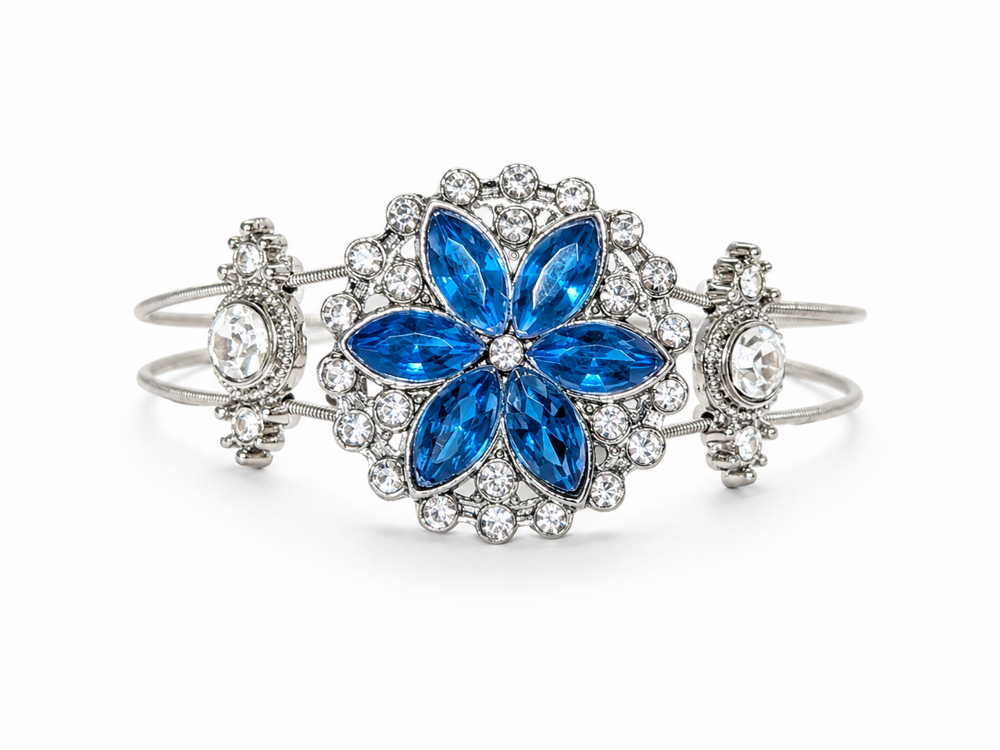 Jewelry bracelet with blue flower design and clear stones on a white background