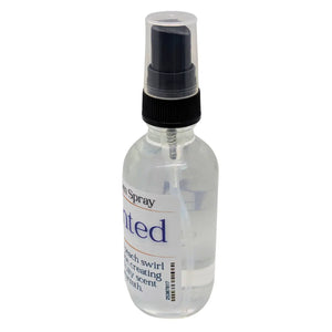 Bottle of ENCHANTED™ RESILMIST™ room spray with a clear bottle, black spray nozzle, and a product label.