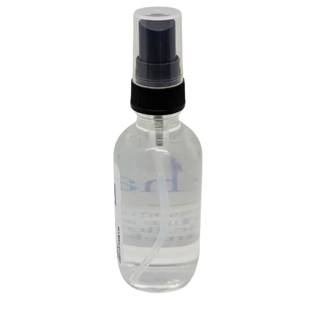 Clear spray bottle with black nozzle and cap, partially visible label with clear liquid inside