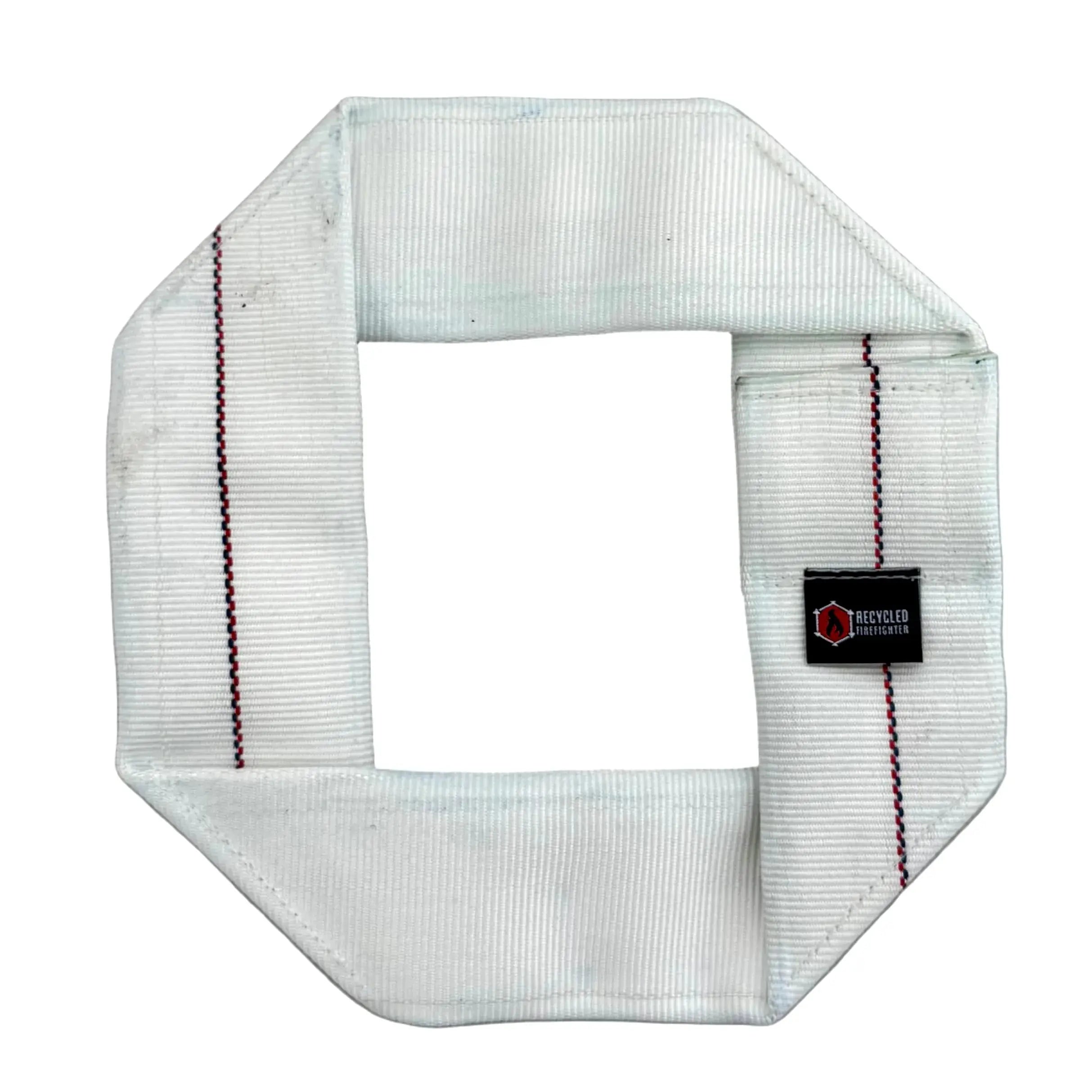 Octagonal white fire hose dog frisbee with red and blue stripes and a black label.