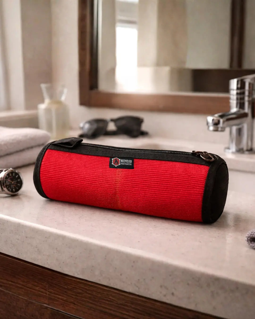 Red cylindrical toiletry bag with black trim and a zipper closure