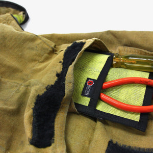 Recycled fire hose tool pouch holding pliers and screwdriver.