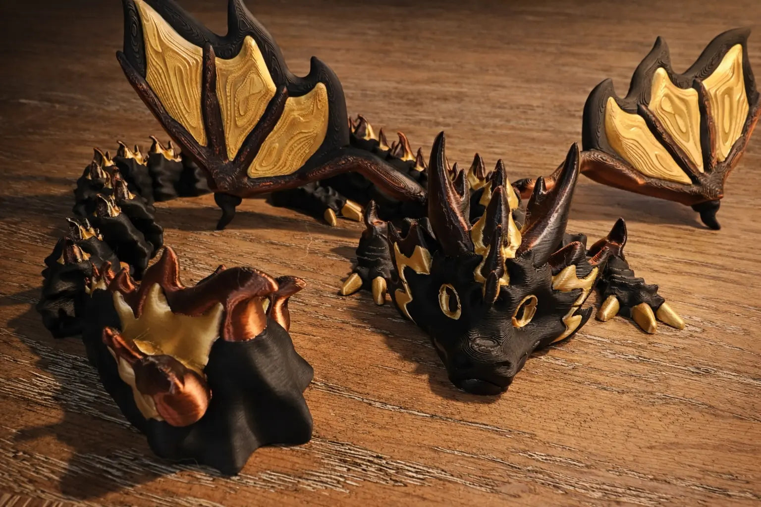 Articulated black and gold dragon with wings, 3D printed.