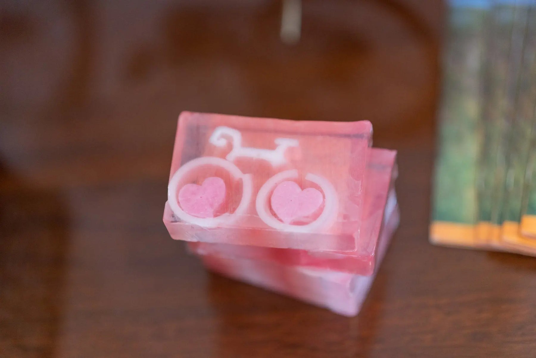 Grapefruit bike love soap slice with pink hearts and transparent layers.