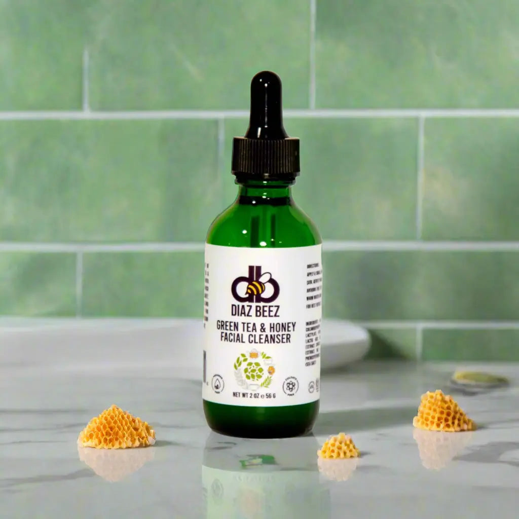 Diaz Beez Green Tea & Honey Facial Cleanser in a green bottle with honeycomb pieces on a marble surface.