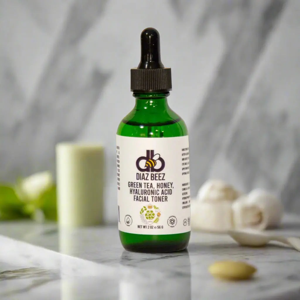 Diaz Beez Green Tea, Honey, & Hyaluronic Acid Facial Toner in green bottle with dropper on marble surface.