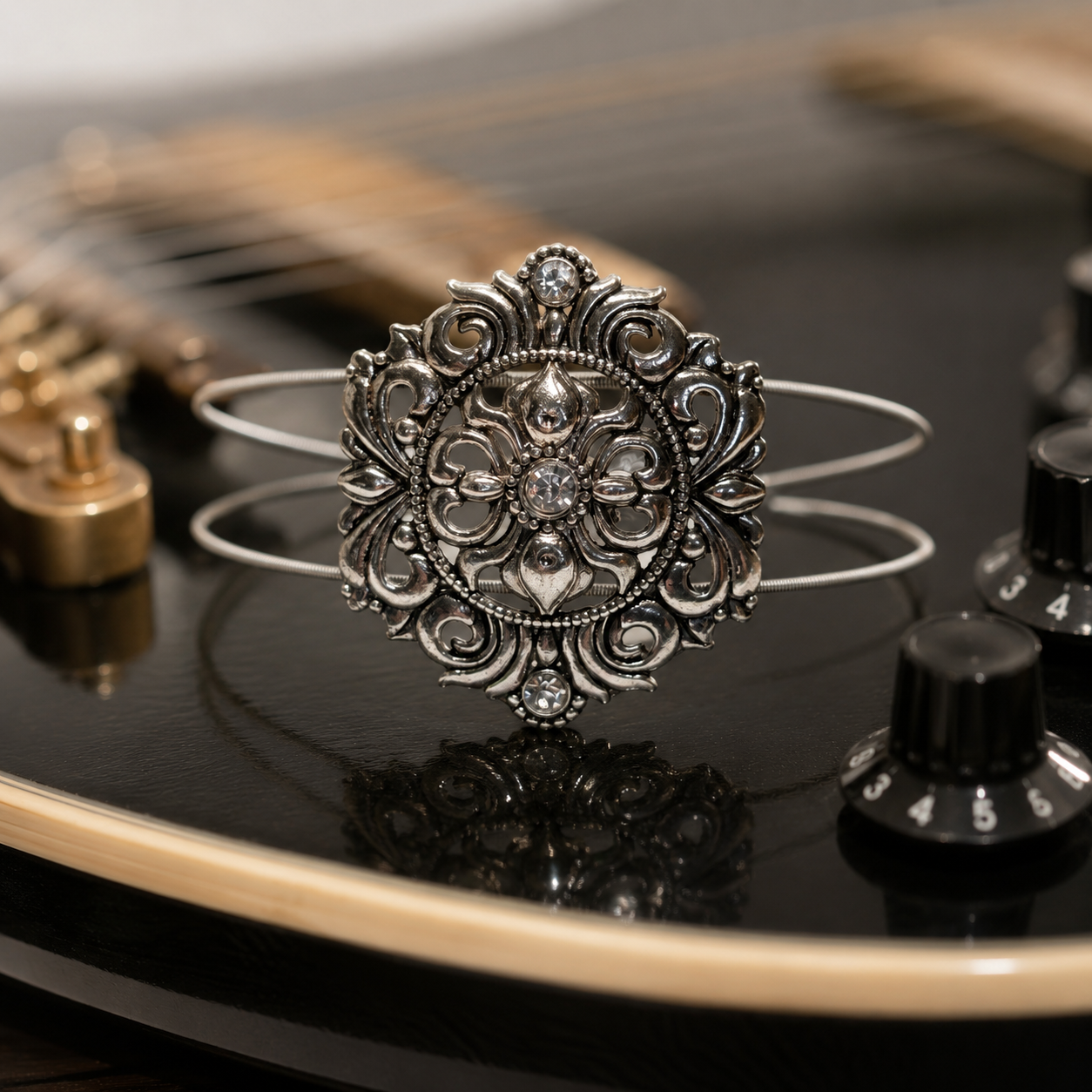Silver medallion guitar string bracelet on guitar