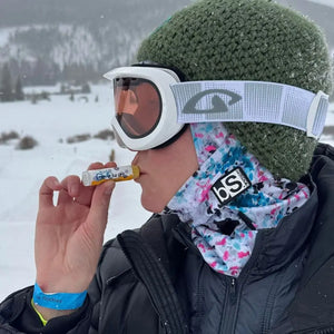 HONEY VANILLA SPF 15 LUBE FOR THE LIPS™ lip balm being applied outdoors.