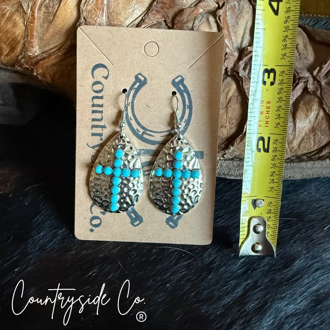 Silver cross dangle earrings with turquoise stones on hammered finish.