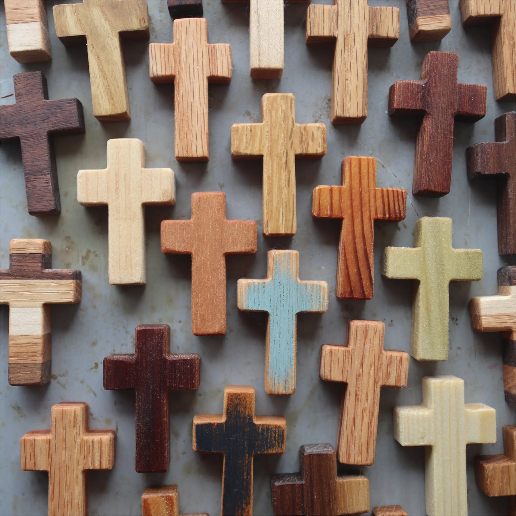 A collection of assorted wooden crosses in various natural wood tones.