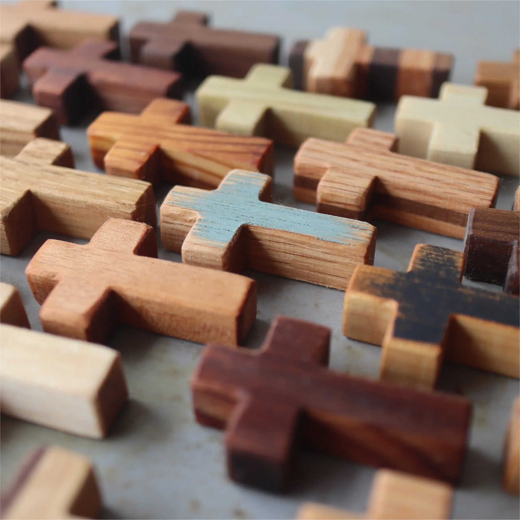 Group of handmade wooden pocket crosses in various wood grains.