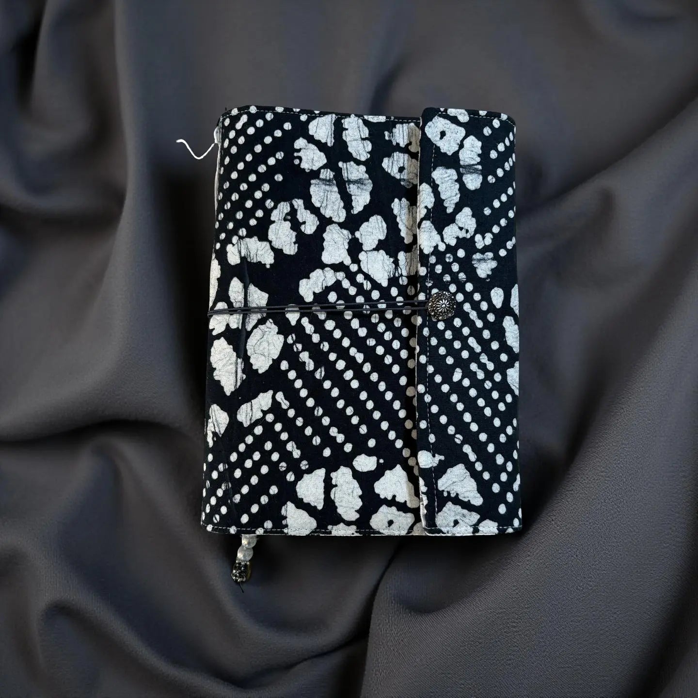 Hand-sewn journal with black and white pattern, button and elastic closure by Main Street Collective.