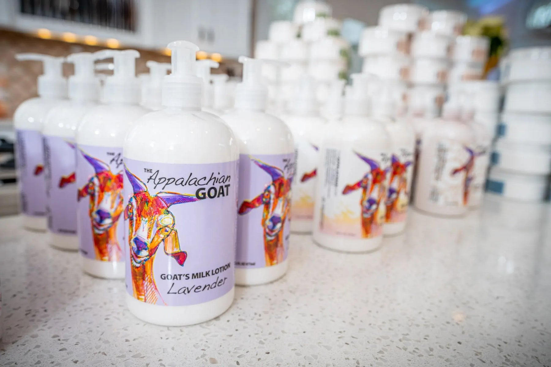 Lavender goat milk lotion bottles with colorful goat illustrations.