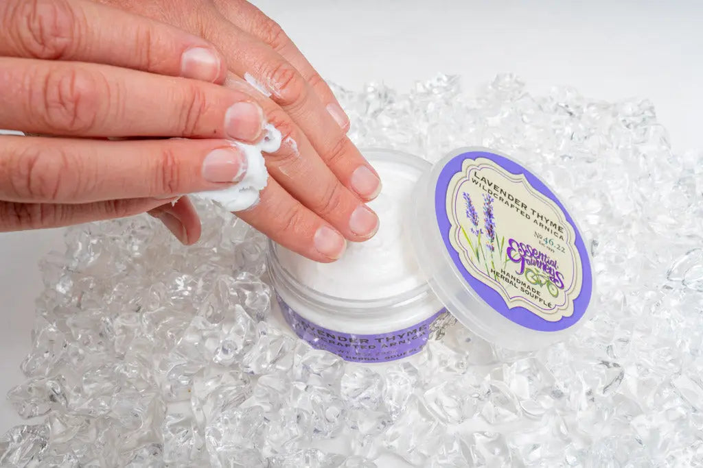Hands applying Lavender Thyme Arnica Soufflé from a jar surrounded by ice.