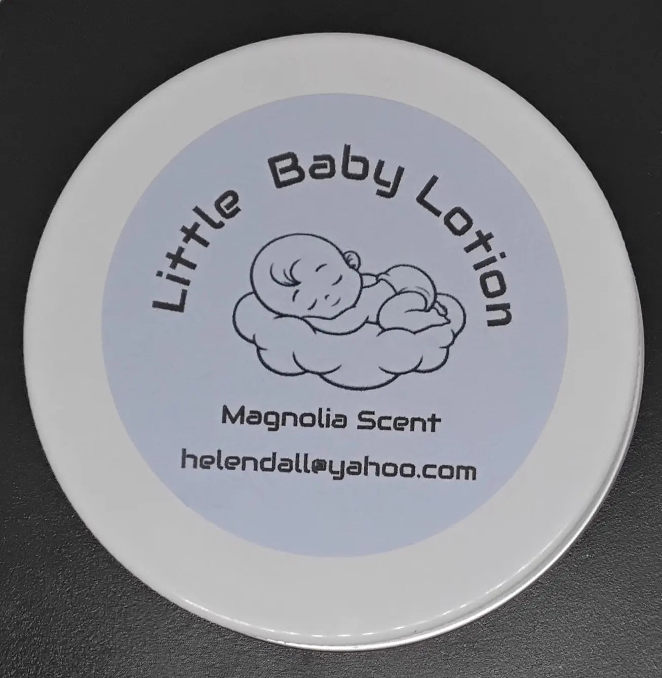 A jar of Little Baby Lotion with a baby illustration and "Magnolia Scent" text on the label.