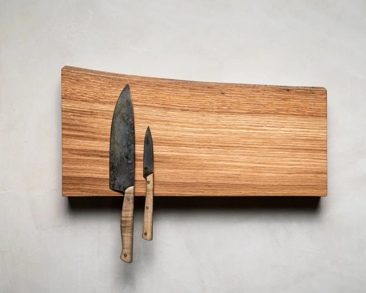 Magnetic Wooden Knife Holder with chef's knife and paring knife on light wood board against a neutral gray wall background