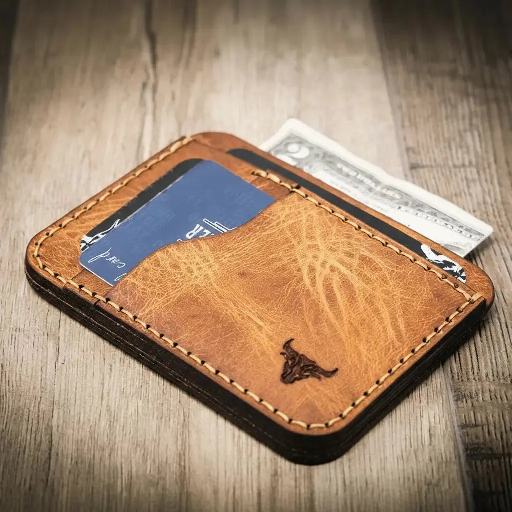 Brown stitched leather minimalist wallet holding cards and cash with a bull logo.