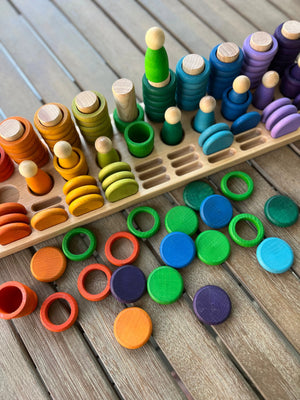 Wooden sorting tray with colorful rings and peg dolls