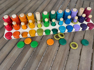 Wooden toy sorting tray with colorful stacked and scattered wooden pieces.