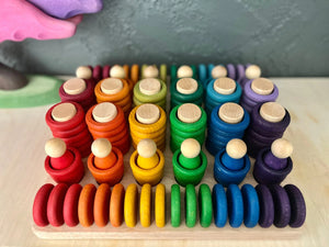 Maple sorting tray filled with colorful wooden stacking toys and rings.