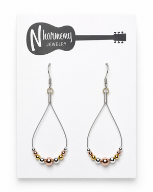 Teardrop-shaped earrings with multicolored beads on a Harmony Jewelry card.