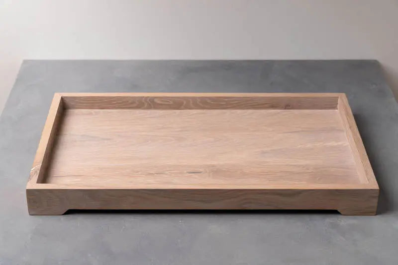 Wooden tray: A rectangular light-colored wood tray with a raised border is on a gray surface.